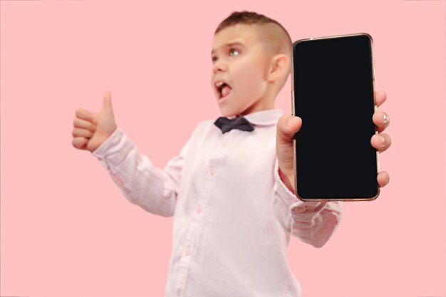 Indoor portrait of attractive young boy holding blank smartphone