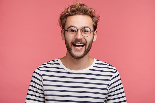 Indoor portrait of bearded young man with trendy hairstyle