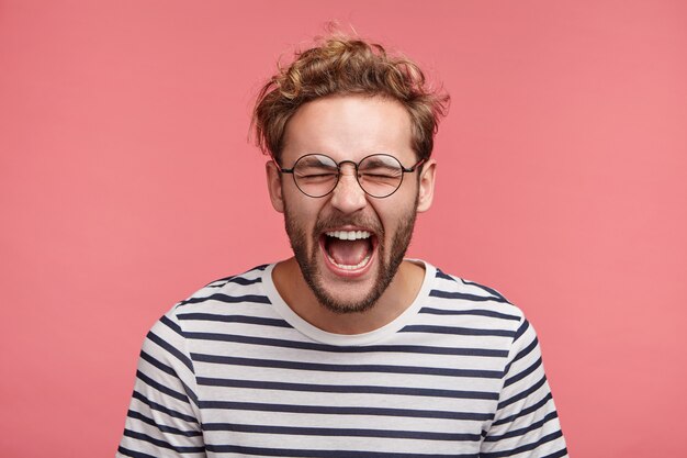 Indoor portrait of bearded young man with trendy hairstyle