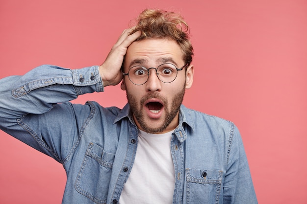 Indoor portrait of bearded young man with trendy hairstyle