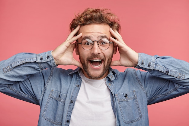 Indoor portrait of bearded young man with trendy hairstyle