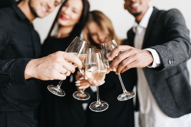 Indoor portrait of romantic blonde woman chilling at friend's party and posing with glass full of champagne