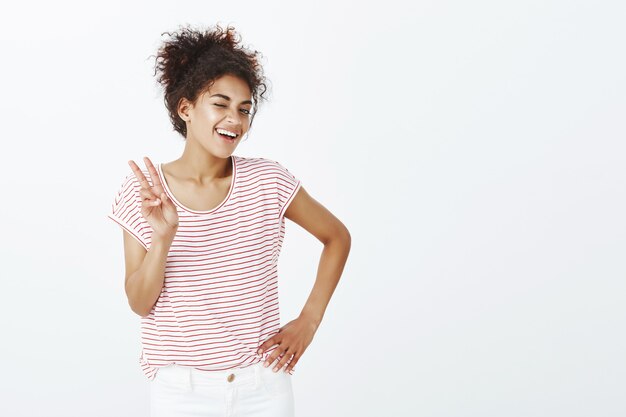 Indoor shot of confident woman with afro hairstyle posing in the studio