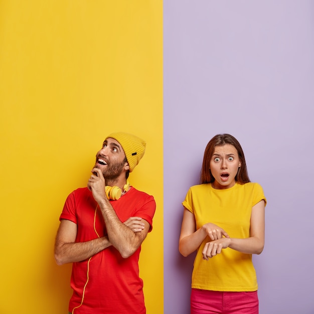 Free Photo indoor shot of glad millennial couple posing against the dual colored wall