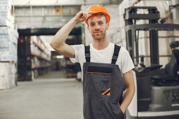 Free photo industrial worker indoors in factory. young technician with orange hard hat.