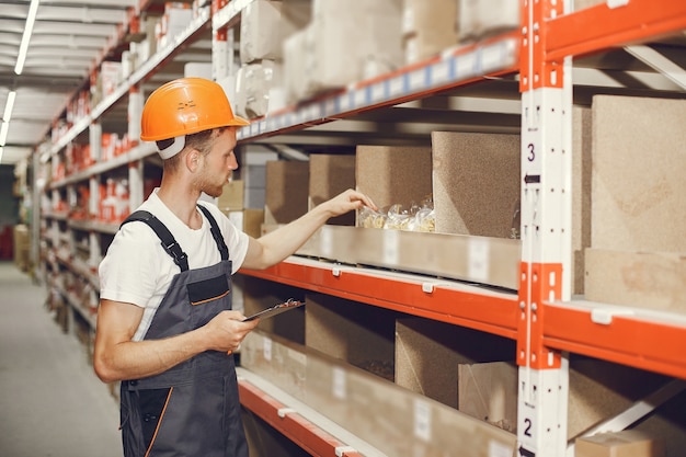 Free Photo industrial worker indoors in factory. young technician with orange hard hat.