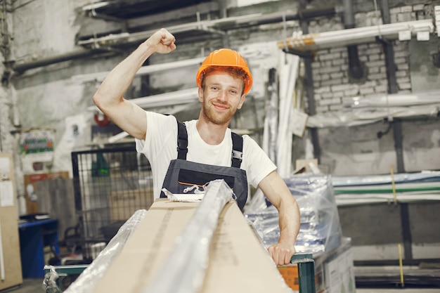 Free photo industrial worker indoors in factory. young technician with orange hard hat.