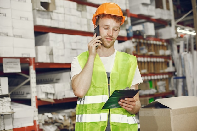 Free photo industrial worker indoors in factory. young technician with orange hard hat.