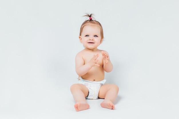 Infant child baby girl toddler crawling happy looking straight isolated on a white wall