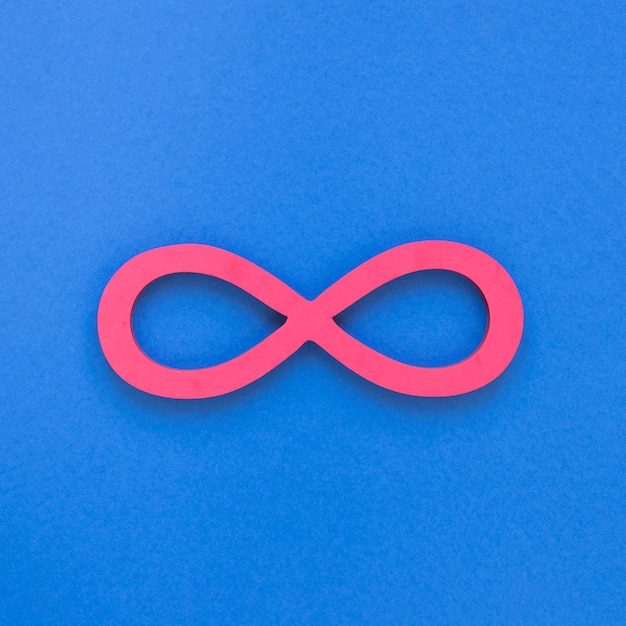 Free photo infinite pink symbol on blue background