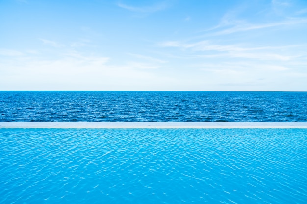 Infinity swimming pool with sea and ocean view on blue sky