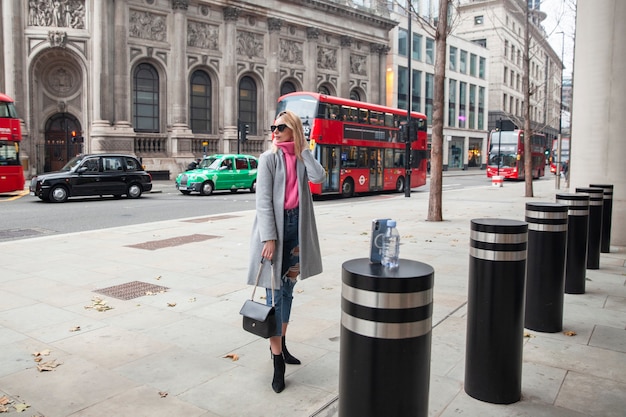 Free photo influencer taking a selfie using a smartphone placed on a pylon in the city