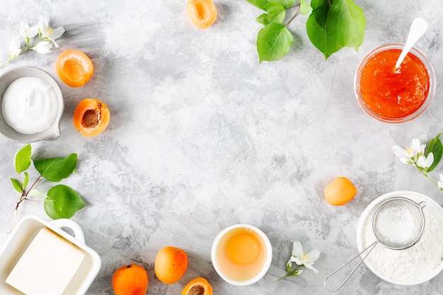 Ingredients for baking a shortbread cake with apricots Butter sugar eggs apricot jam Top view Copy space