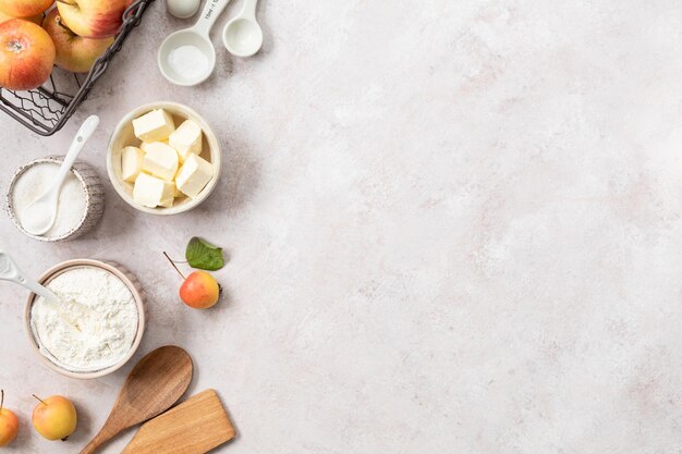 Ingredients for a sweet apple pie on a stone light background