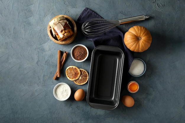 Free photo ingredients and tools for baking nuts pumpkin and cinnamon sticks on gray background top view