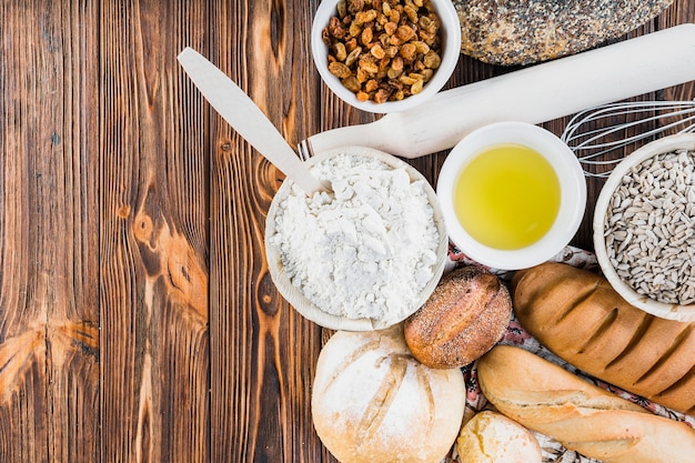 Free photo ingredients with freshly baked breads on the wooden table