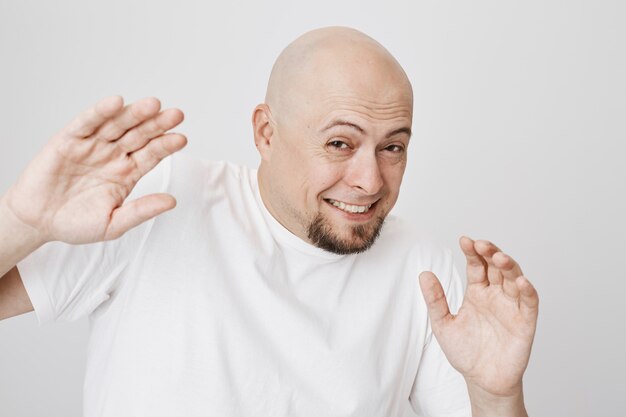 Insecure scared guy raising hands and grimacing afraid of punch