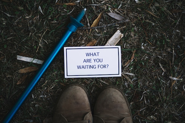 Free photo inspirational writing near walking stick and boots