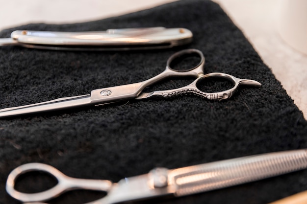 Instruments of hairdresser on black towel