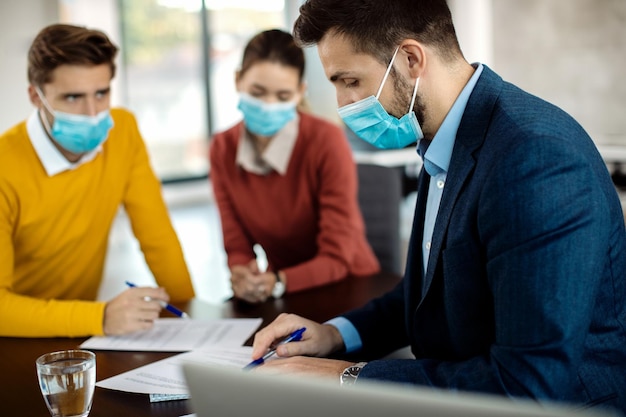 Free photo insurance agent going through paperwork while having a meeting with clients during covid19 pandemic