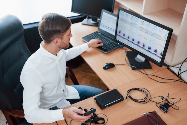 Free Photo interesting results. polygraph examiner works in the office with his lie detector's equipment