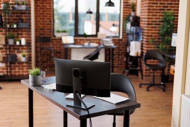 Free Photo interior of empty company office with furniture and nobody in it. modern business marketing agency workspace with contemporary desks and desktop computers displaying financial charts.