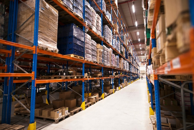 Interior of large distribution warehouse with shelves stacked with palettes and goods ready for the market