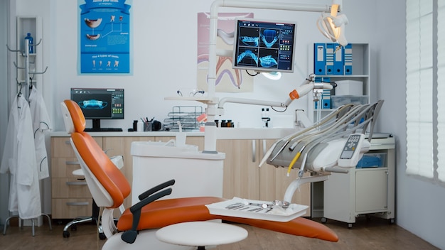 Free photo interior of modern equipped dental office with x ray on monitors, dentist stomatology orthodontic workplace