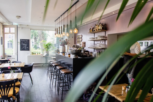 Free photo interior shot of a cafe with chairs near the bar with wooden tables