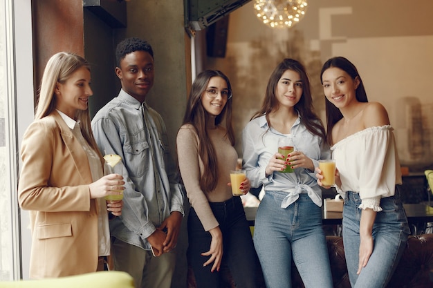 Internationals people standing in a cafe and drinking a cocktails