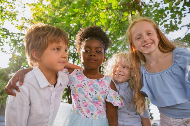 Interracial group of kids posing together at the park