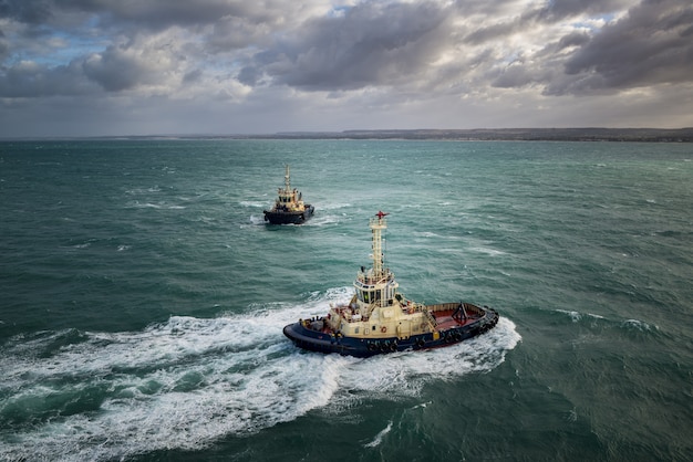 Free Photo investigative boats sailing in the turquoise ocean under the cloudy sky