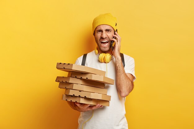 Irritated deliveryman with pizza boxes