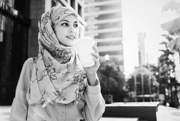 Islamic woman drinking coffee in the city