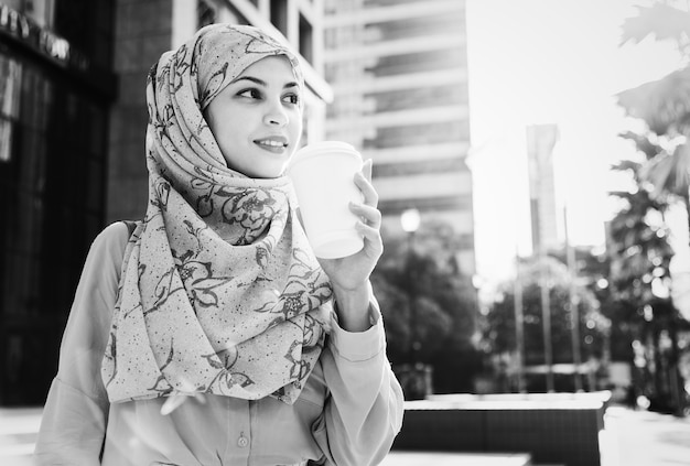 Islamic woman drinking coffee in the city