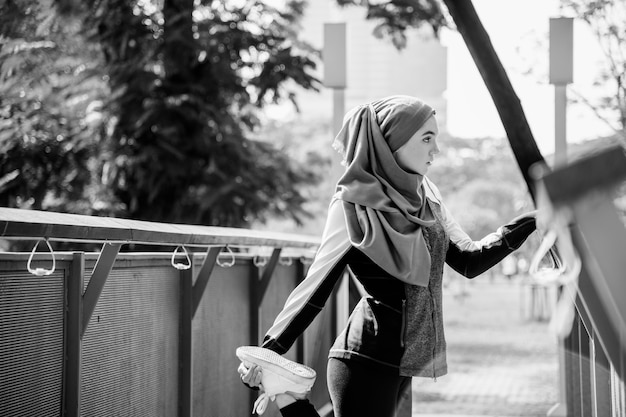 Free photo islamic woman stretching after workout at the park