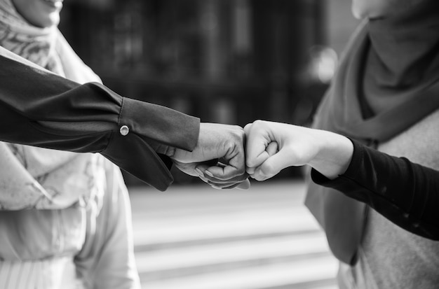 Free photo islamic women friends fist bumps