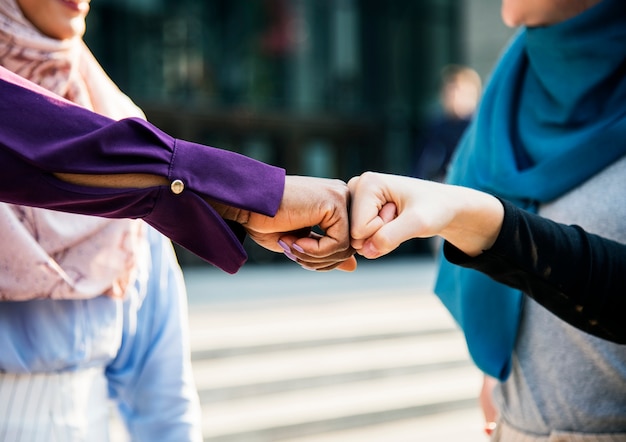 Free Photo islamic women friends fist bumps