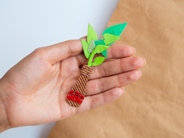 Free photo isolated homemade paper plant held in hand