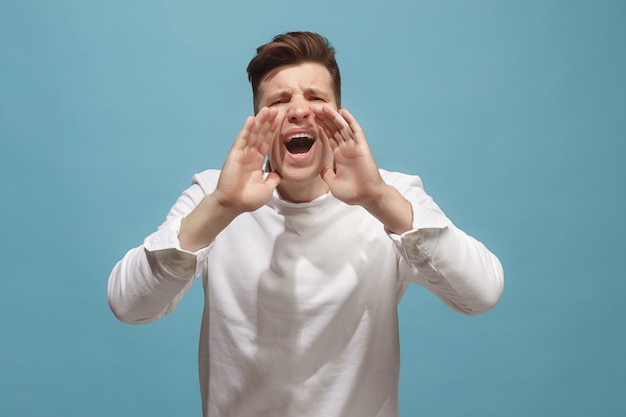 Isolated on pink young casual man shouting at studio