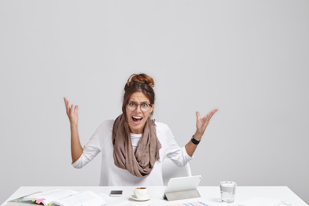 Free Photo isolated portrait of annoyed unhappy young female entrepreneur dressed in casual clothes gesturing actively and exclaiming,