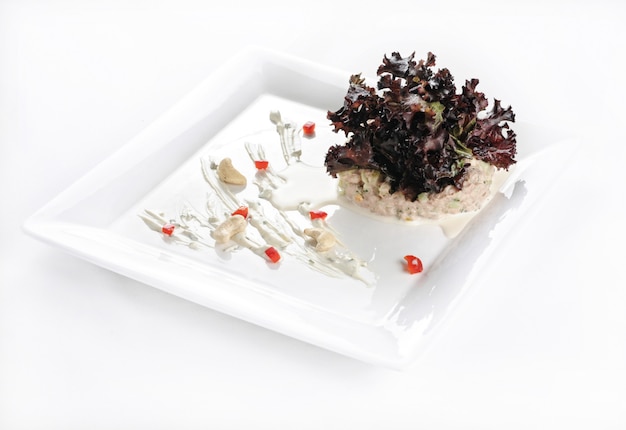 Isolated shot of a white plate with a delicious salad - perfect for a food blog or menu usage