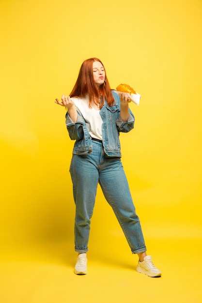 It's easier to be follower. Don't need to take photo with food. Caucasian woman's on yellow background. Beautiful female red hair model. Concept of human emotions, facial expression, sales, ad.