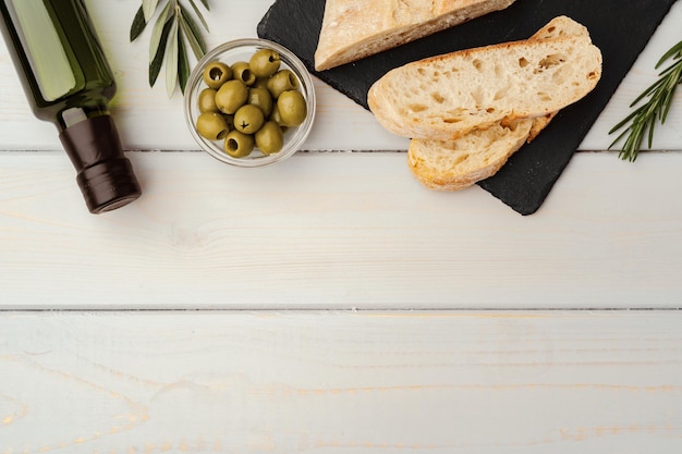 Italian ciabatta bread with olive oil on wooden background