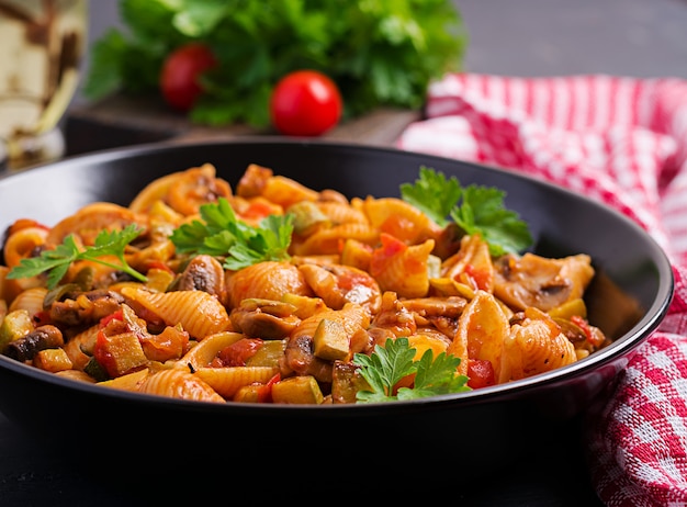 Italian pasta shells with mushrooms, zucchini and tomato sauce