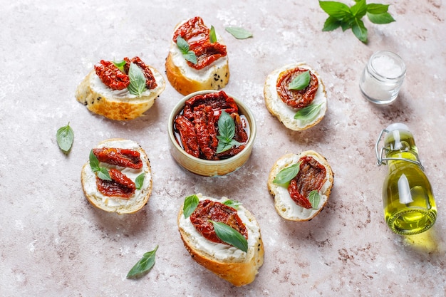 Italian sandwiches - bruschetta with cheese, dry tomatoes and basil