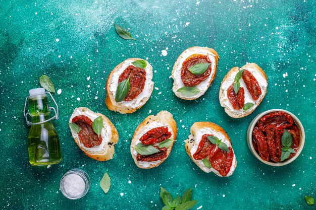 Italian sandwiches - bruschetta with cheese, dry tomatoes and basil.