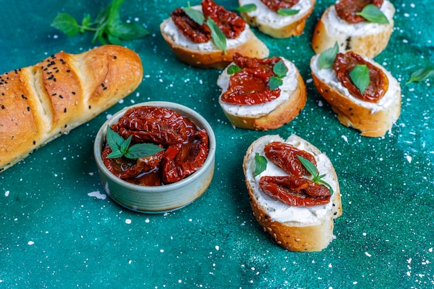 Italian sandwiches - bruschetta with cheese, dry tomatoes and basil.