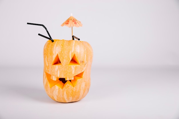 Free photo jack-o-lantern decorated with umbrella and straws