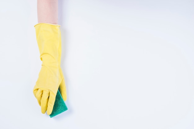 Free photo janitor's hand with yellow gloves holding sponge on white background